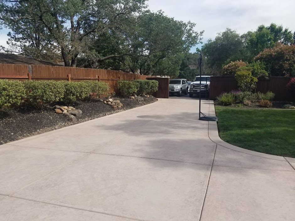Concrete driveway with drought-tolerant landscaping and bark mulch beds